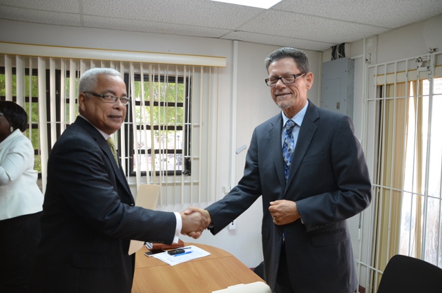 Prime Minister Marcel Gumbs shakes hands with Chairman of the Electoral Council Bert Hofman on Tuesday after signing his declaration.
